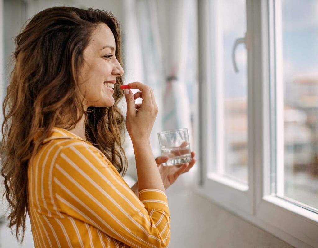Lady taking an Oral Supplement